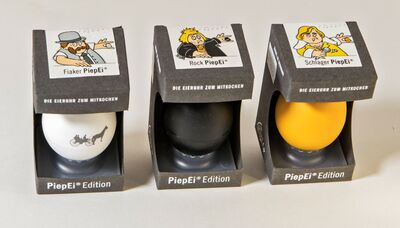 Ansicht auf drei verpackte PiepEier Diaker, Rock und Schlager mit gezeichneten Hühnern.