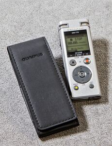 Ansicht auf ein silberfarbenes Gerät mit danebenliegender schwarzer Hülle in Lederoptik.