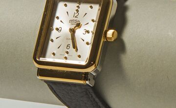 Ansicht auf die Uhr an einer transparenten Halterung.