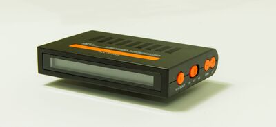 Ansicht auf den Funkreisewecker im schwarzen Gehäuse mit orangenen Tasten.