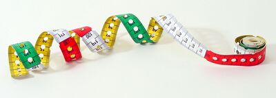 Ansicht auf das bunte Maßband. Es ist im Wechsel gelb, grün, weiß und rot.