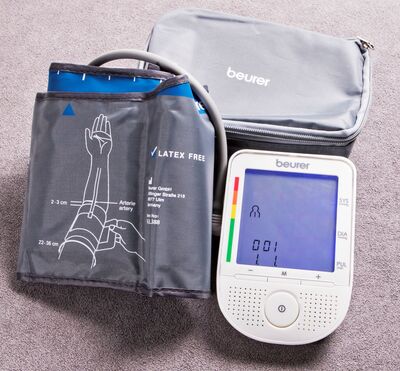 Ansicht auf das Blutdruckmessgerät mit Manschette und Gerät im weißen Gehäuse