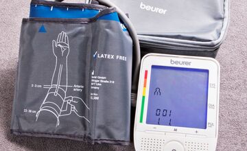 Ansicht auf das Blutdruckmessgerät mit Manschette und Gerät im weißen Gehäuse