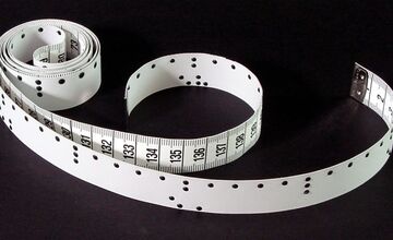 Ansicht auf ein weißes Maßband mit Beschriftung und Punktschrift.