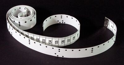 Ansicht auf ein weißes Maßband mit Beschriftung und Punktschrift.