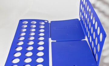 Ansicht auf das dunkelblaue Wäschefaltbrett, ausgeklappt.