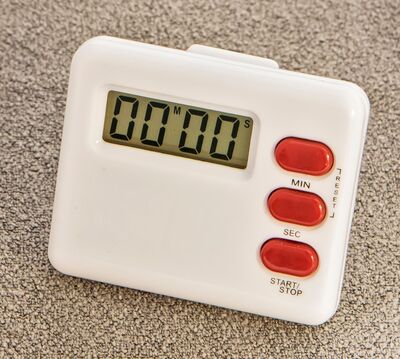 Ansicht auf einen Kurzzeitwecker in Weiß mit drei roten Knöpfen and er rechten Seite.