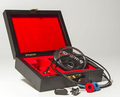 Ansicht auf eine geöffnete Kiste mit Kabeln und einer weiteren durchsichtigen Verpackung mit der Aufschrift Soundman.